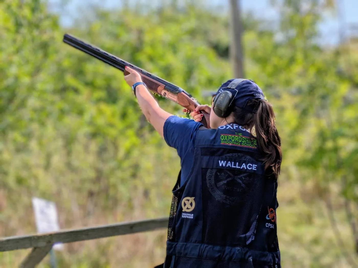A member in an Oxford vest shooting at a clay
